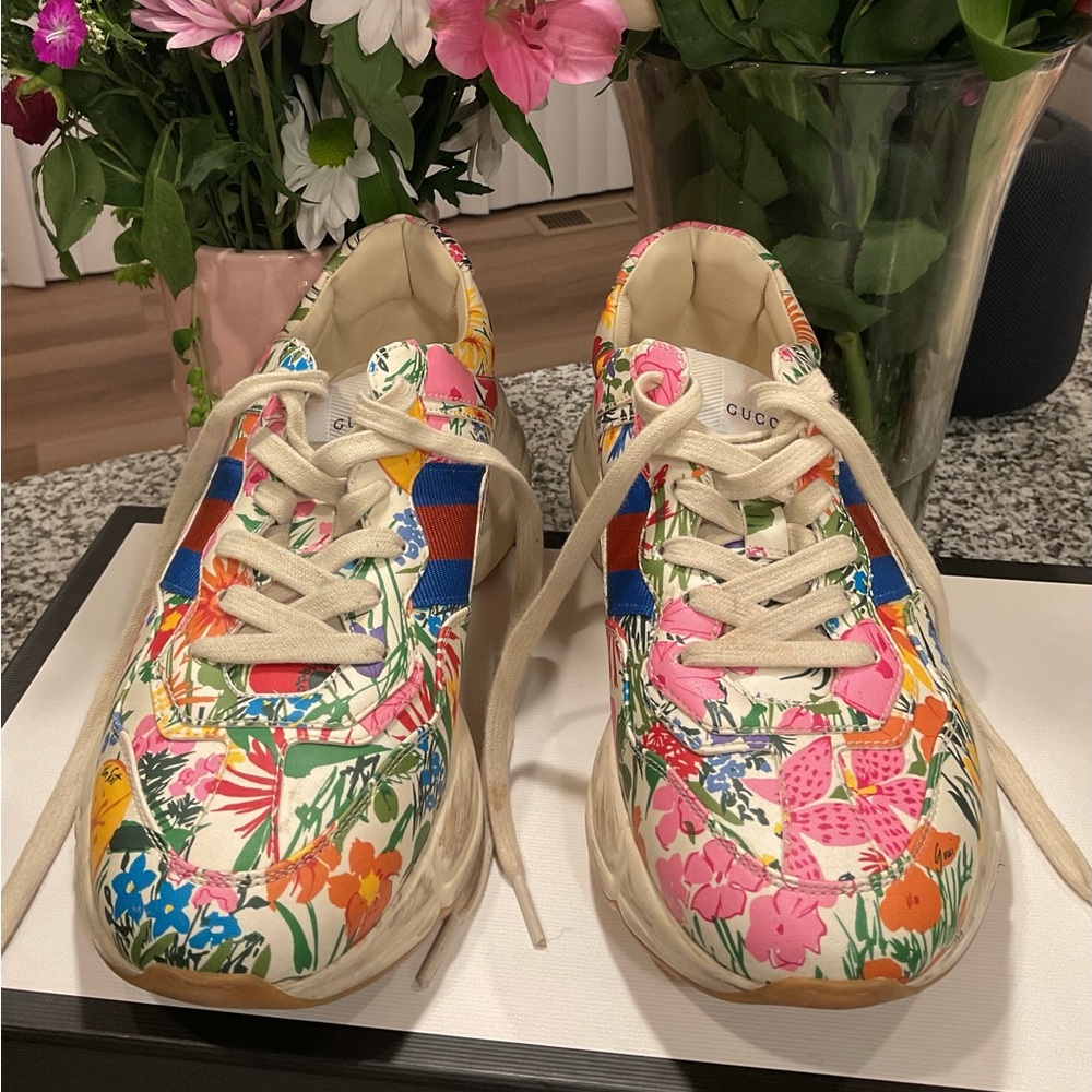 The shoes are Gucci Rhyton Floral Sneakers. Gucci x Ken Scott collaboration.